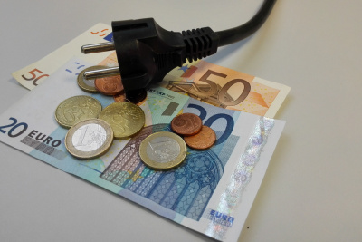 Stecker liegt lose auf Geldscheinen und Euromünzen